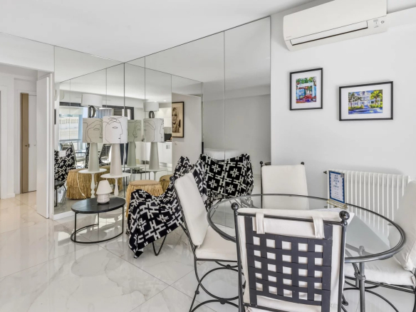 Interior of a renovated studio with modern furniture and mirror, located on the top floor in Cannes.