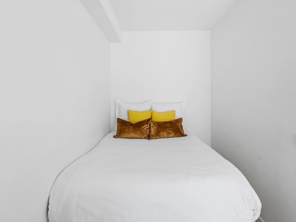 Renovated studio apartment with bed and pillows in a residence in Cannes.