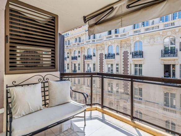 Terrace of a renovated studio on the top floor with a view of a building in Cannes.