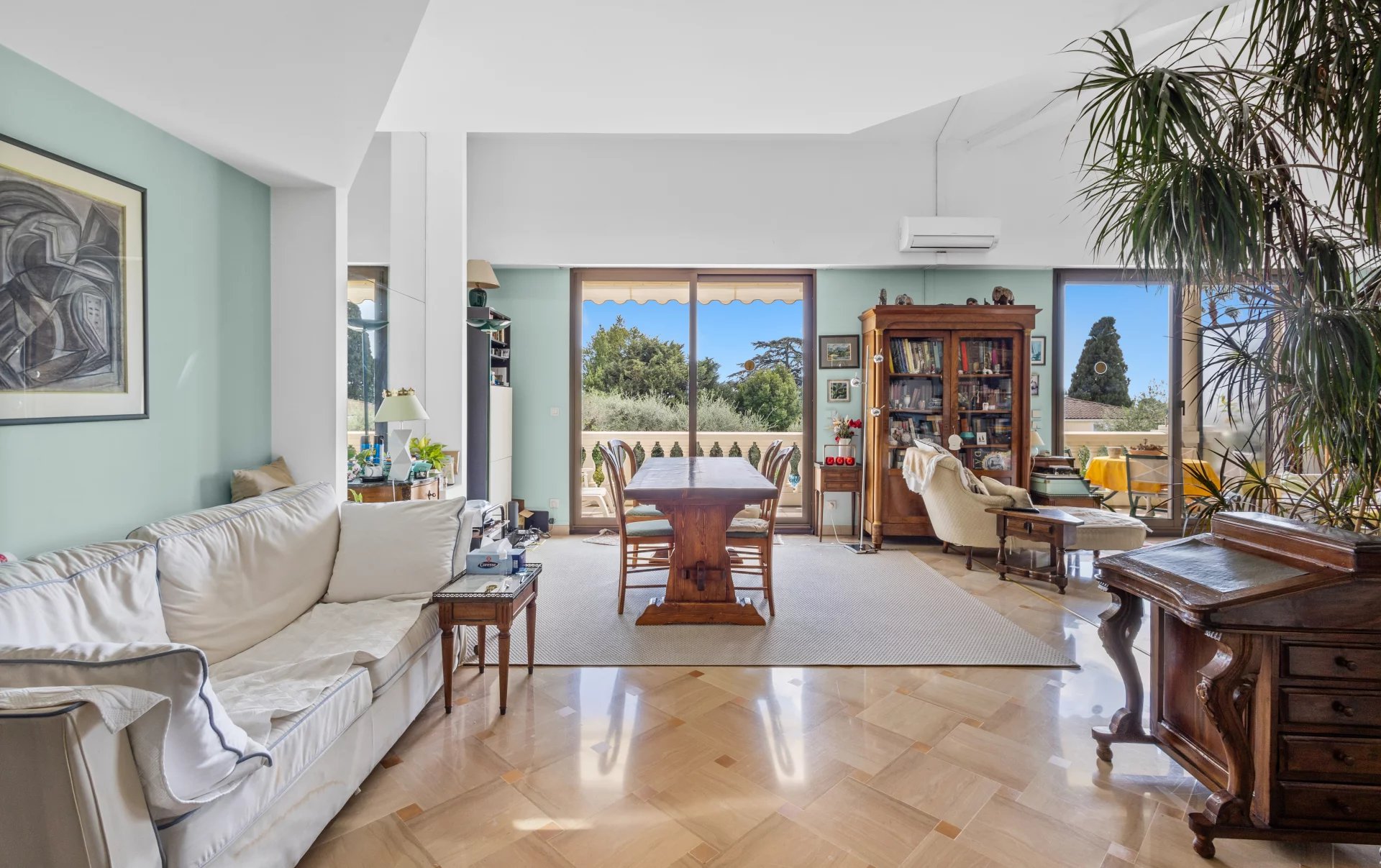 Intérieur d'un appartement en duplex à Cannes avec salon lumineux et vue sur l'extérieur.