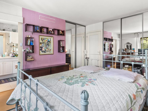Chambre d'un appartement en duplex à Cannes avec lit et miroir.