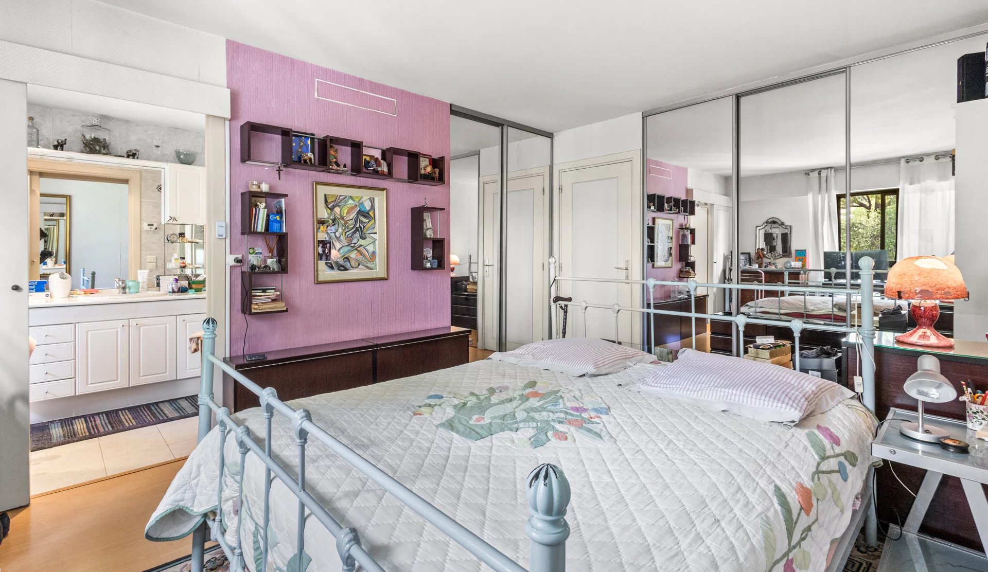 Chambre d'un appartement en duplex à Cannes avec lit et miroir.