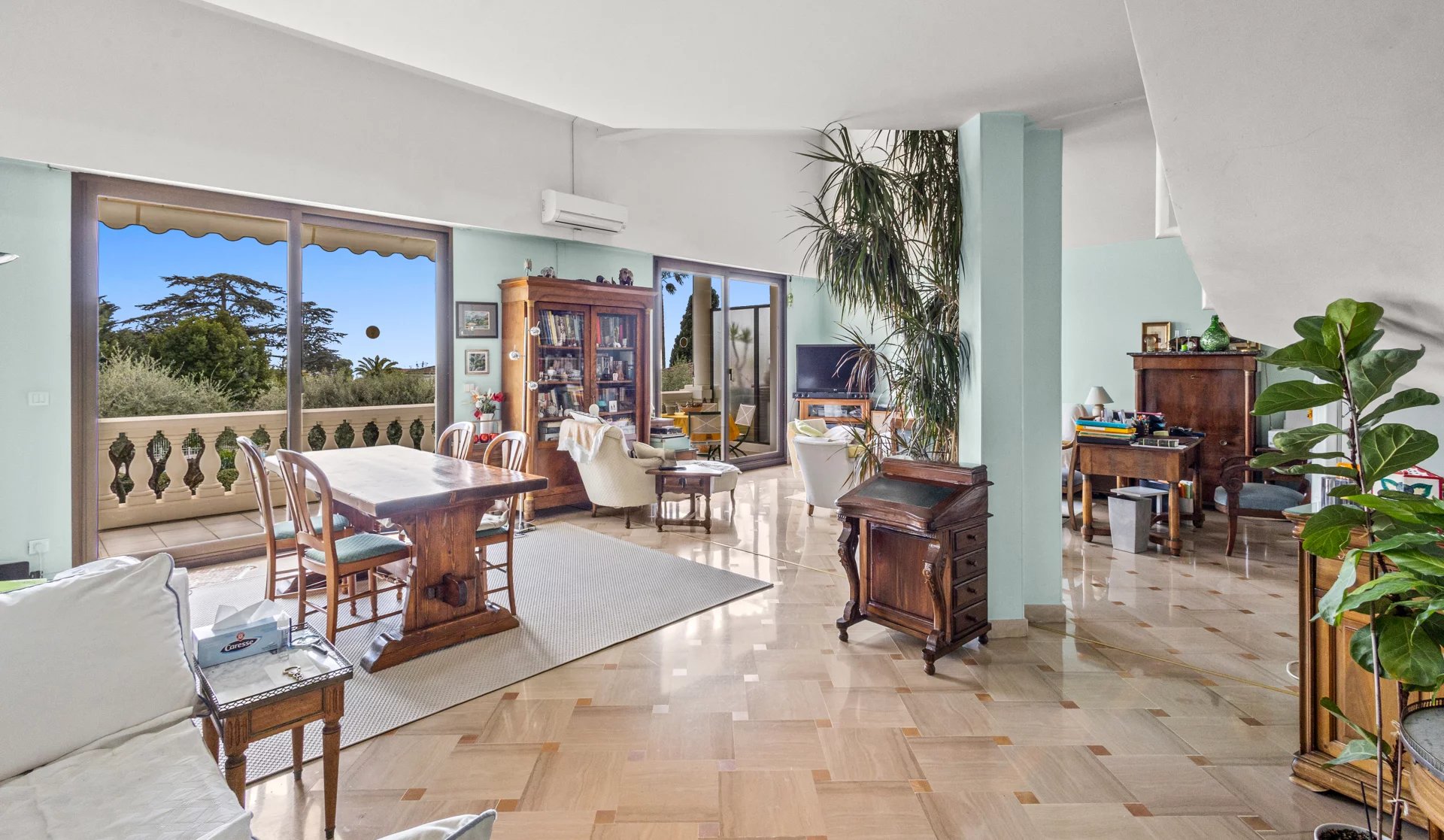 Intérieur d'un appartement en duplex à Cannes, avec salon lumineux et vue sur la nature.