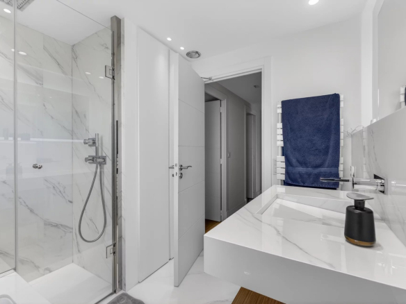 Salle de bain moderne avec douche en verre et lavabo sur un plan en marbre