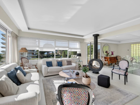 Salon lumineux d'un appartement 5 pièces au Cannet, avec vue sur la piscine et le jardin.
