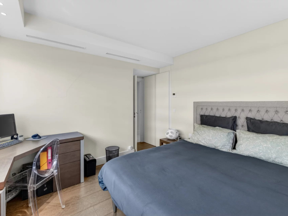 Chambre d'un appartement avec lit double, bureau et décoration moderne.