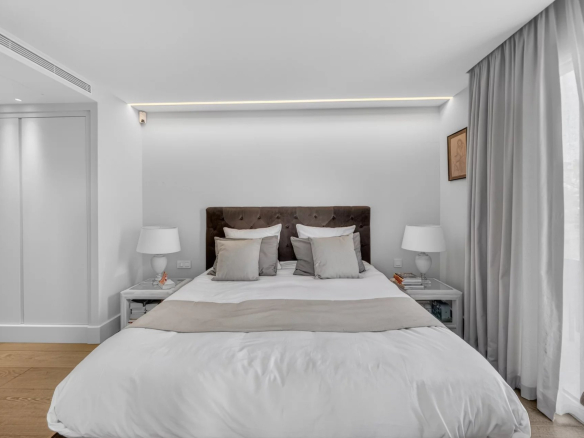 Chambre d'un appartement moderne avec lit double et décoration épurée.