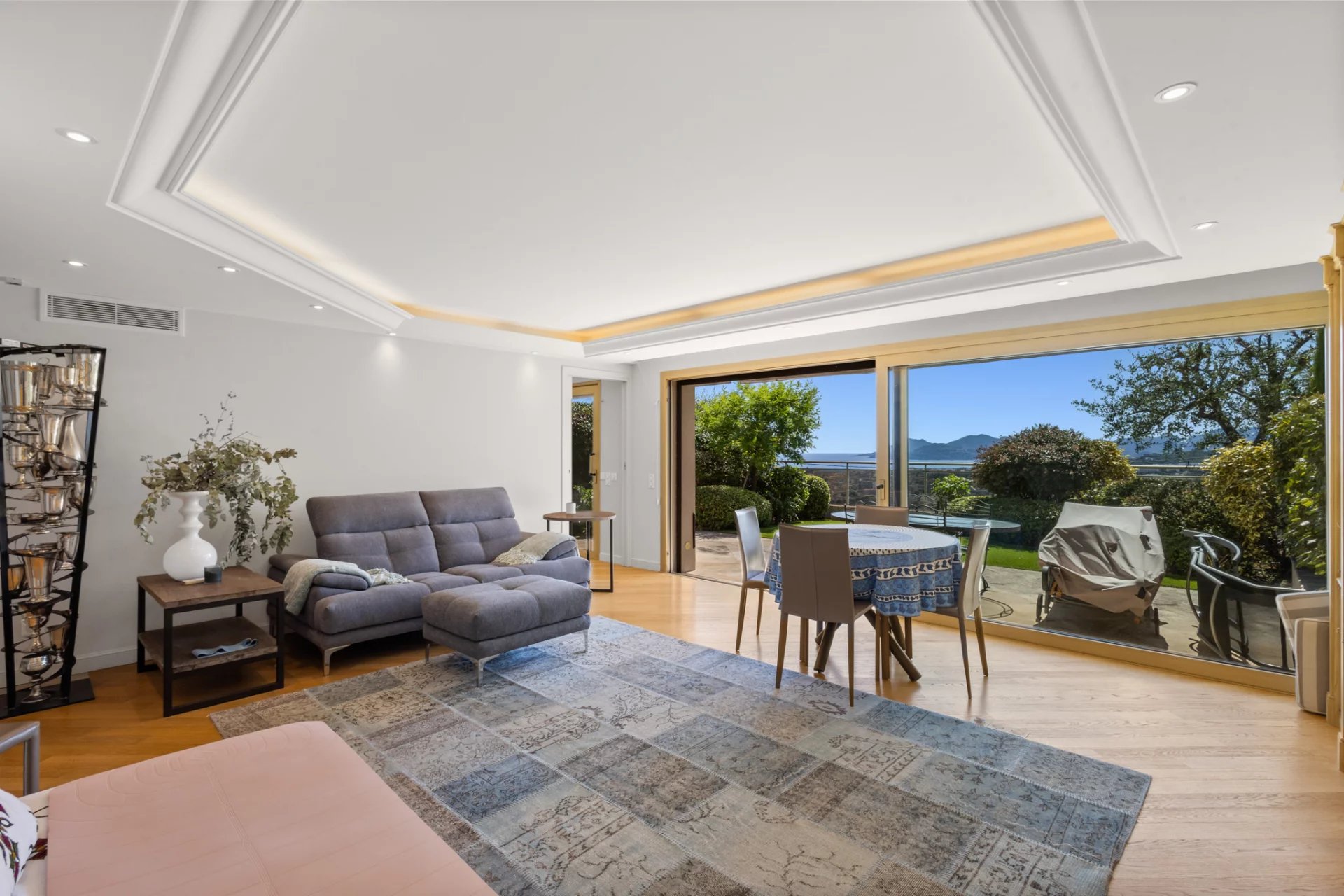 Intérieur d'un appartement avec vue sur la mer, salon lumineux et terrasse.