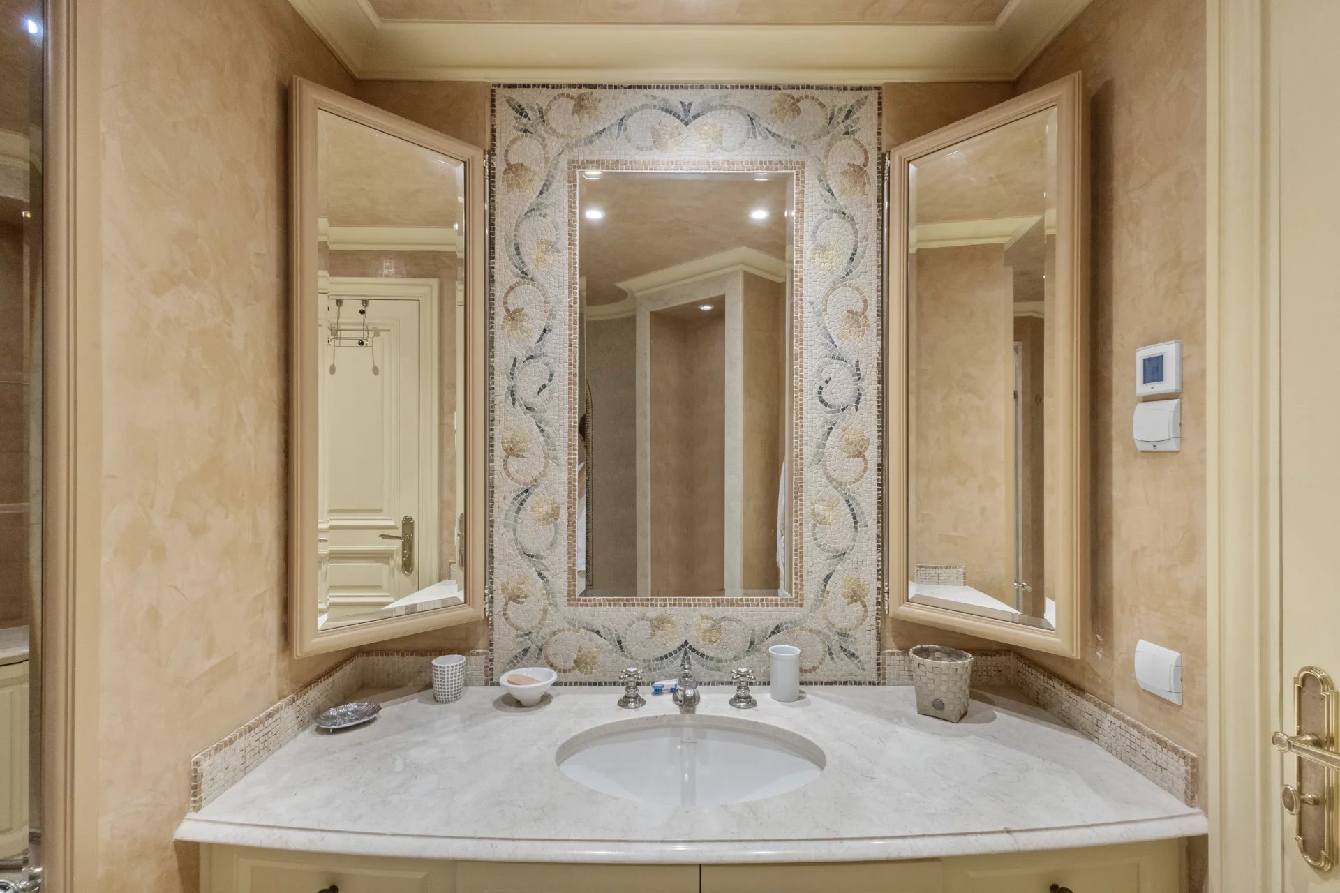 Salle de bain élégante avec double vasque et miroirs décoratifs.
