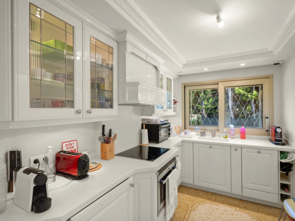 Cuisine moderne et équipée d'un appartement au Cannet, avec fenêtres donnant sur un jardin.