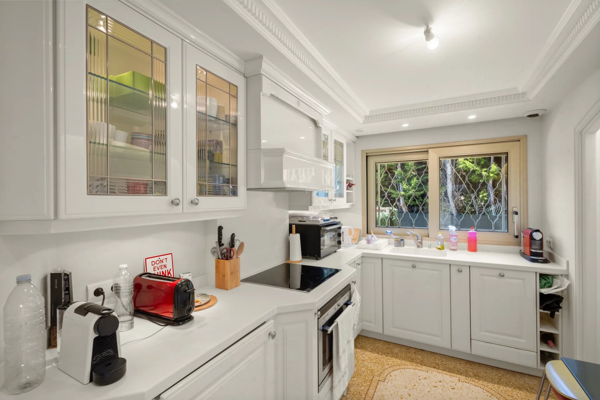 Cuisine moderne et équipée d'un appartement au Cannet, avec fenêtres donnant sur un jardin.