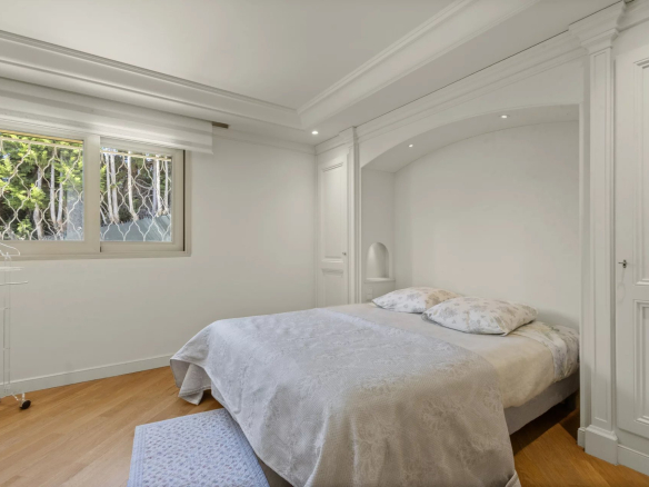 Chambre d'un appartement-villa à Le Cannet avec lit double et fenêtres donnant sur l'extérieur.