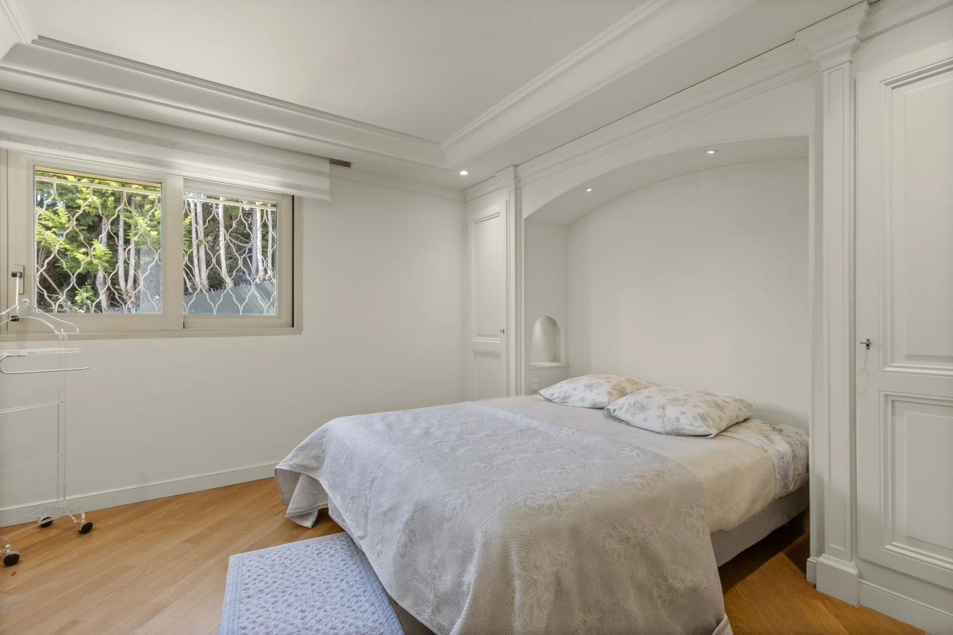 Chambre d'un appartement-villa à Le Cannet avec lit double et fenêtres donnant sur l'extérieur.