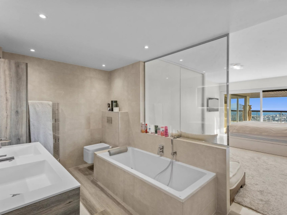 Modern bathroom with bathtub and double sink, sea view in Le Cannet.