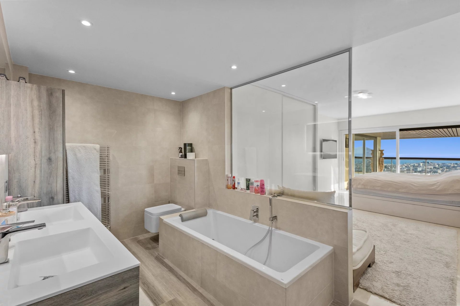 Modern bathroom with bathtub and double sink, sea view in Le Cannet.