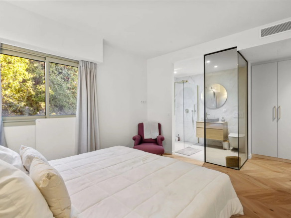 Renovated apartment room with en-suite bathroom and windows overlooking the outside.