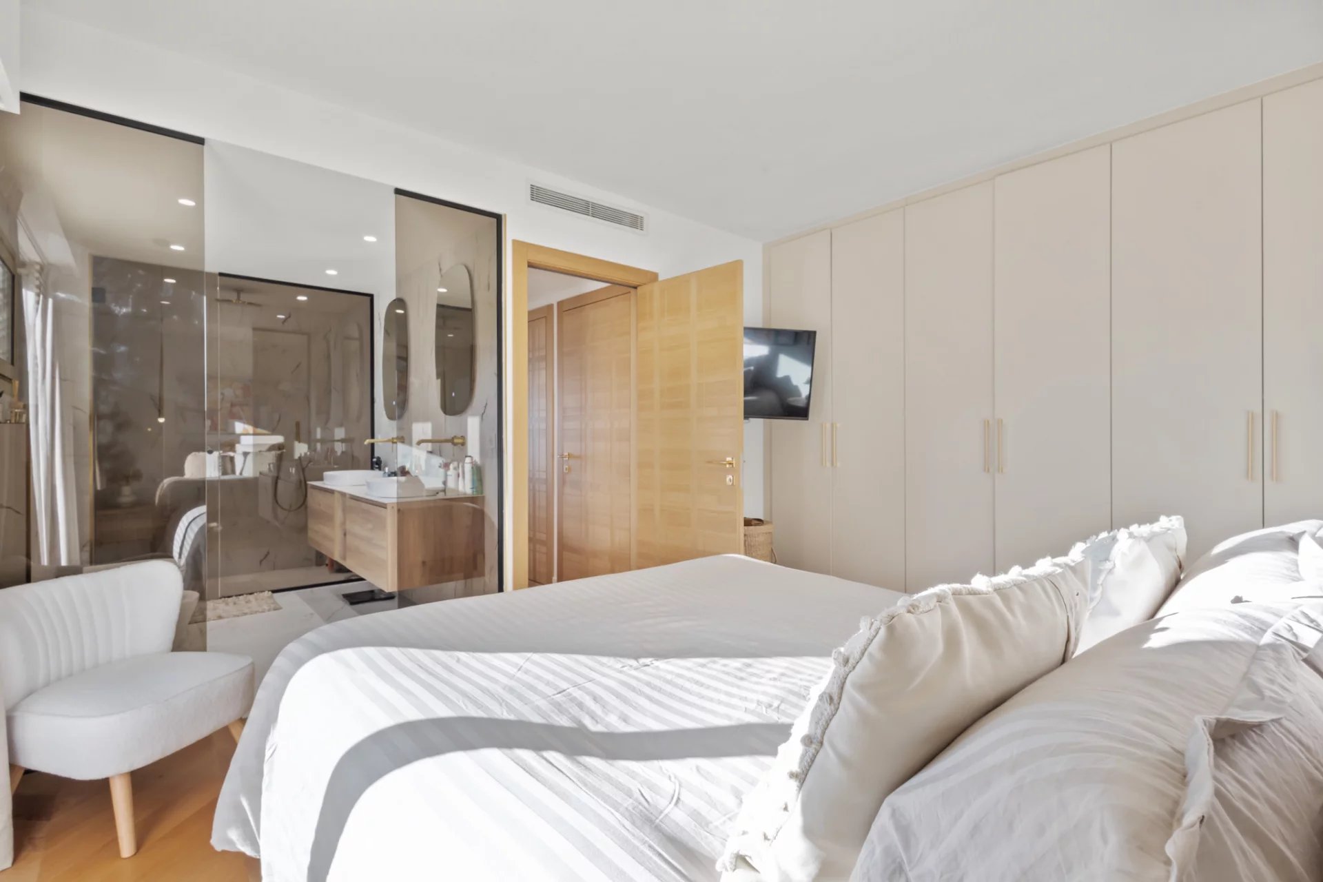 Renovated apartment room in Le Cannet Bedroom in a renovated apartment with bed, wardrobe and bathroom visible in the background.