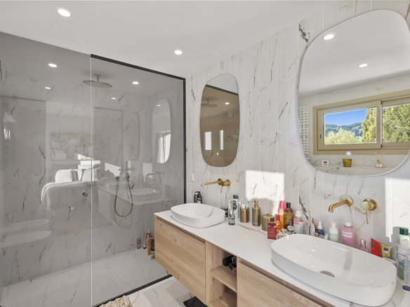 Modern bathroom with walk-in shower and double sink, decorated with elegant tiles.