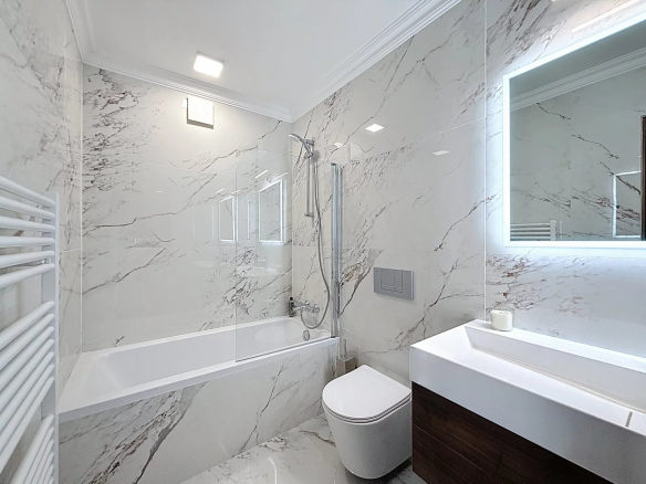 Modern bathroom with bathtub, shower and sink in a renovated duplex.