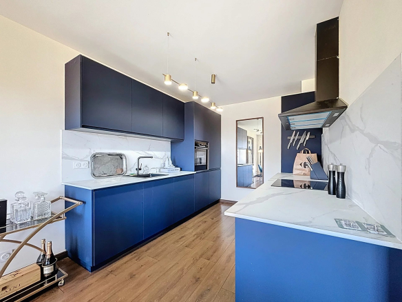 Modern kitchen in a 195m2 duplex in Le Cannet, with blue furniture and marble worktop.