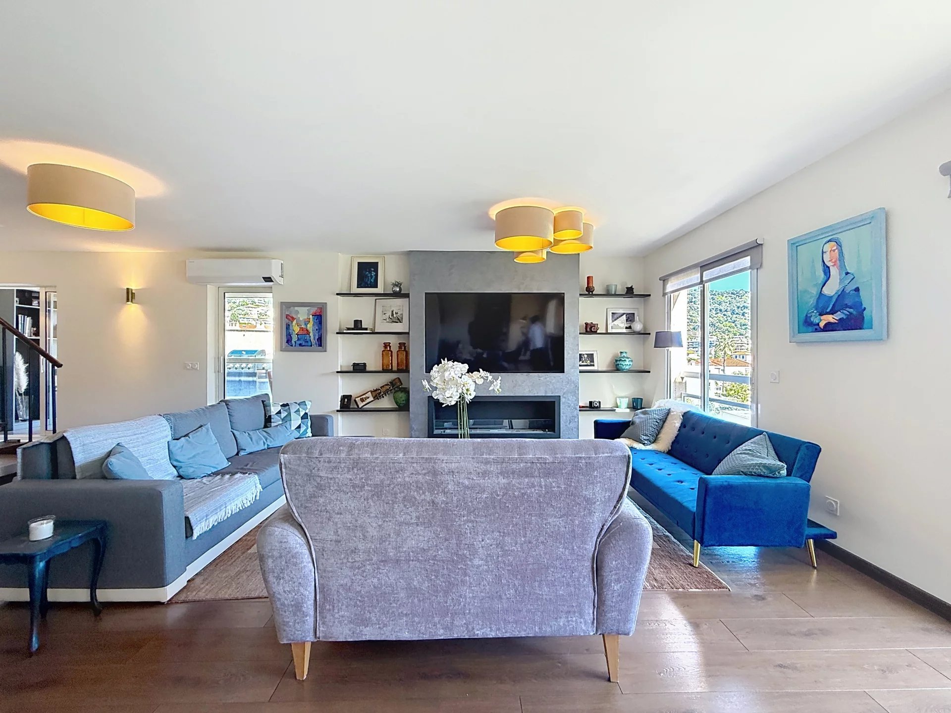 Duplex living room in Le Cannet Spacious living room in a renovated duplex with sofas, television and artwork.
