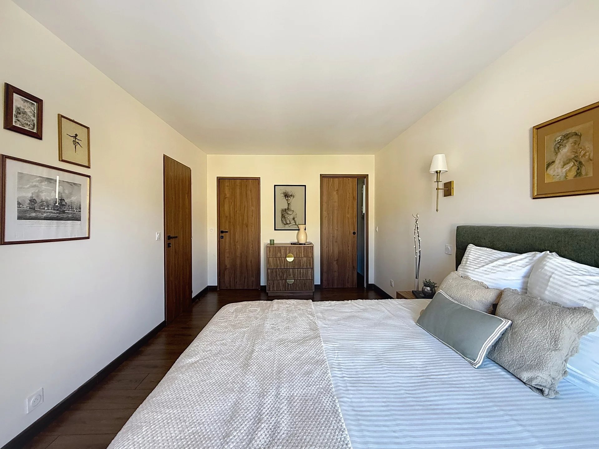 Renovated apartment room Bedroom in a renovated apartment with bed, chest of drawers and wall decorations.