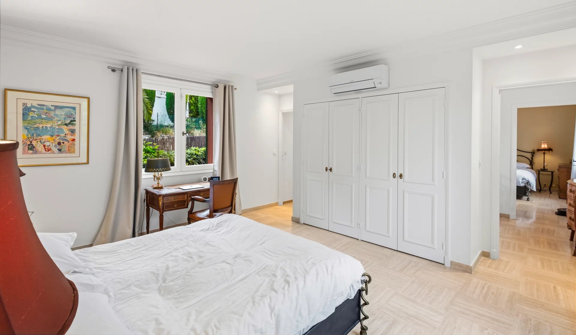 Chambre de villa au Cannet Chambre d'une villa rénovée au Cannet, avec lit, bureau et fenêtre donnant sur un jardin verdoyant.