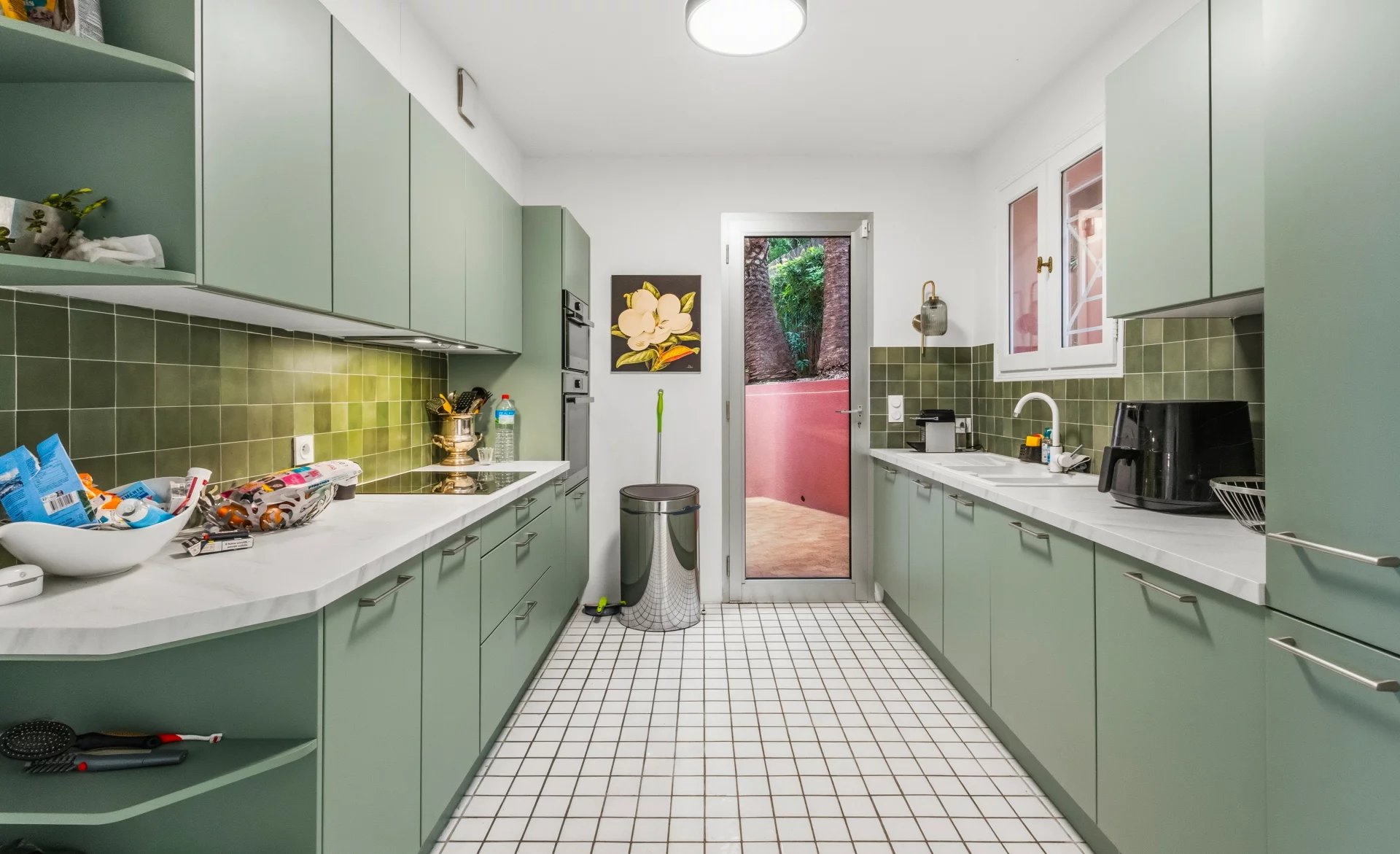 Cuisine d’une villa au Cannet Cuisine moderne et spacieuse d'une villa rénovée au Cannet, avec carrelage blanc et meubles verts.