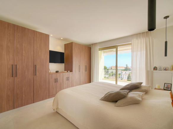 Chambre d'un appartement rénové avec placards intégrés et vue sur l'extérieur, Le Cannet.