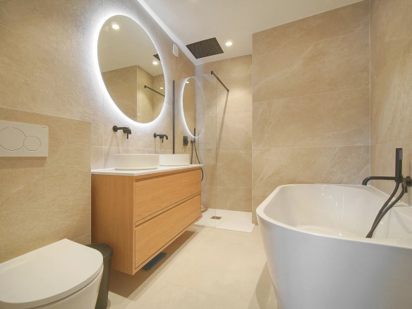 Salle de bain moderne avec baignoire, douche et double vasque en bois.