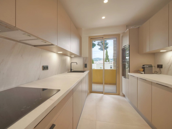 Cuisine moderne d'un appartement rénové au Cannet, avec accès à un balcon.