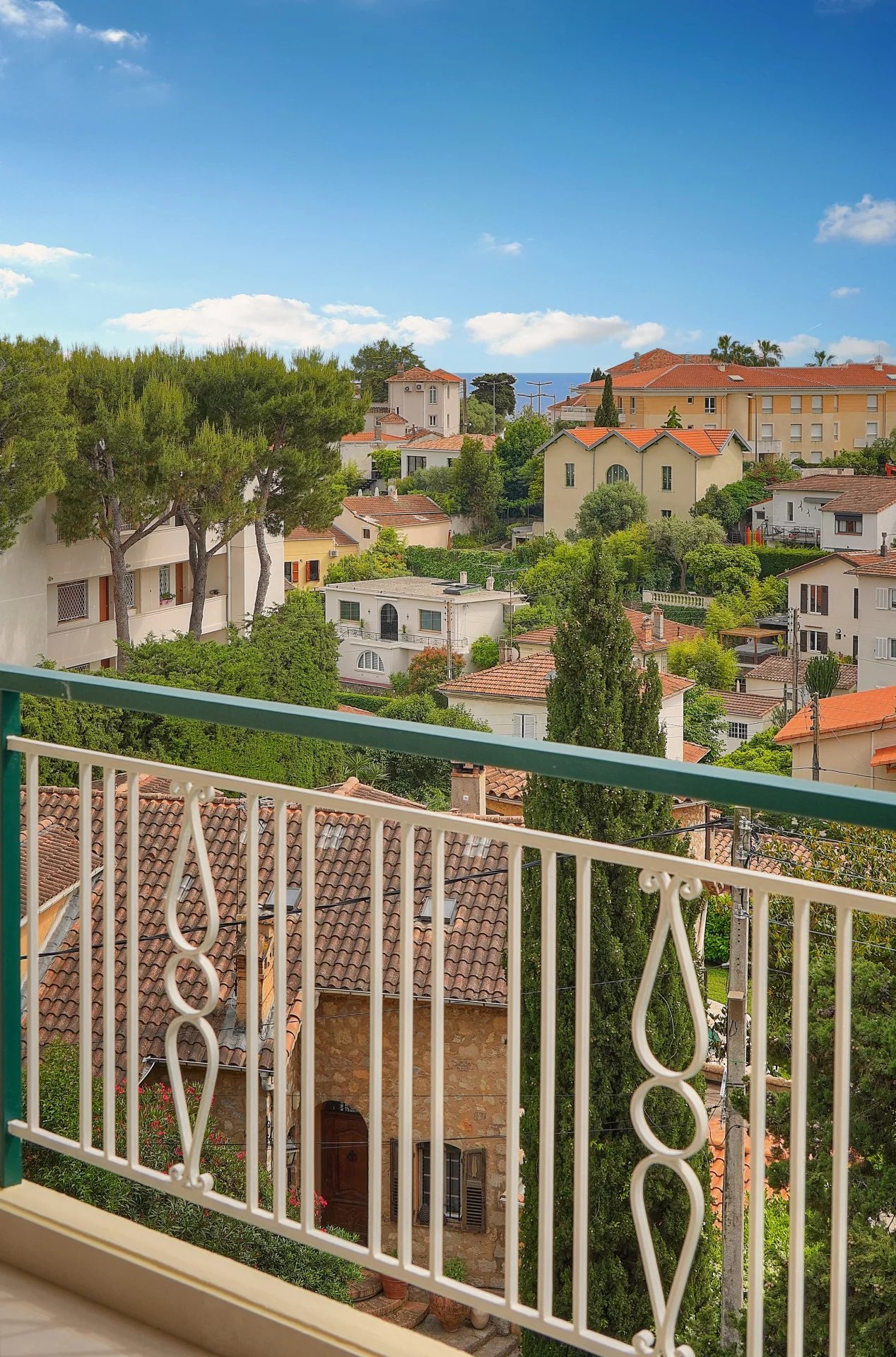 Vue depuis le balcon au Cannet Vue depuis un balcon d'un appartement au Cannet, avec des maisons et de la verdure en arrière-plan.