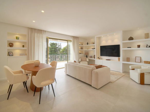 Salon lumineux d'un appartement rénové au Cannet avec terrasse et vue sur la verdure.