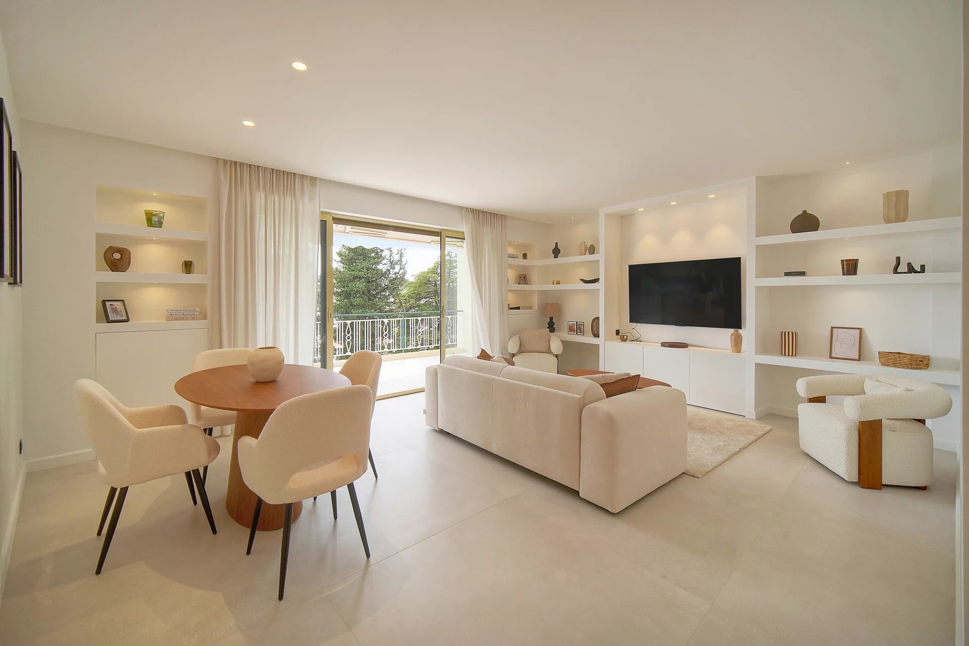 Appartement rénové au Cannet Salon lumineux d'un appartement rénové au Cannet avec terrasse et vue sur la verdure.
