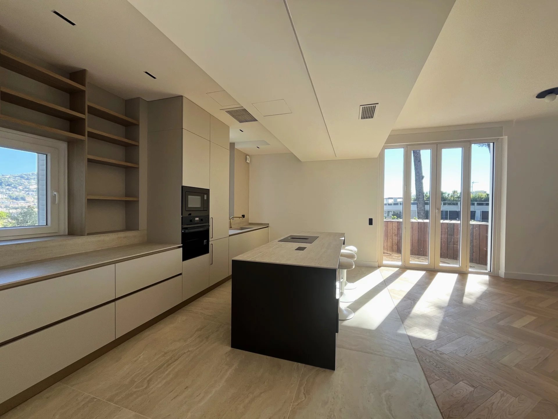 Cuisine d’appartement rénové au Cannet Cuisine moderne et spacieuse d'un appartement rénové au Cannet, avec îlot central et lumière naturelle.