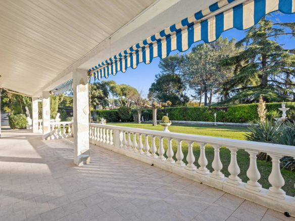 Terrace of a Provençal villa in Mougins with balustrade and landscaped garden in the background.