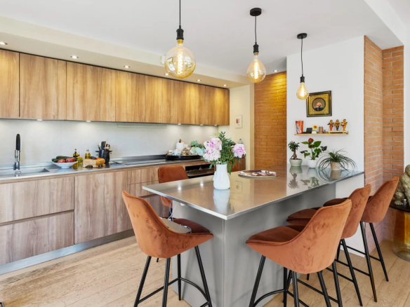 Modern and bright kitchen with a central island and stools in a renovated villa.