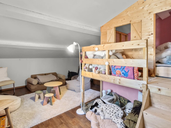 Interior of a renovated villa with a living area and a mezzanine for children.