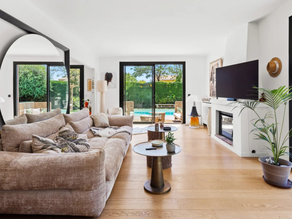 Interior of a renovated villa with a bright and modern living room, overlooking the outdoor pool.
