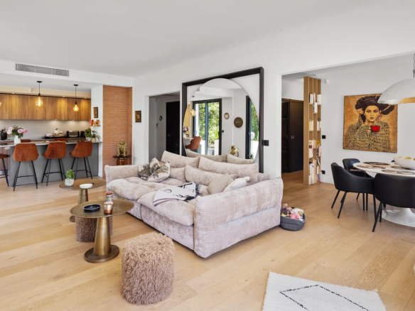Interior of a renovated villa with living room, open kitchen and dining room.