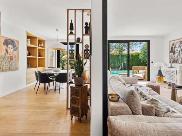 Interior of a renovated villa with a bright living room and dining room, with a view of the outside.