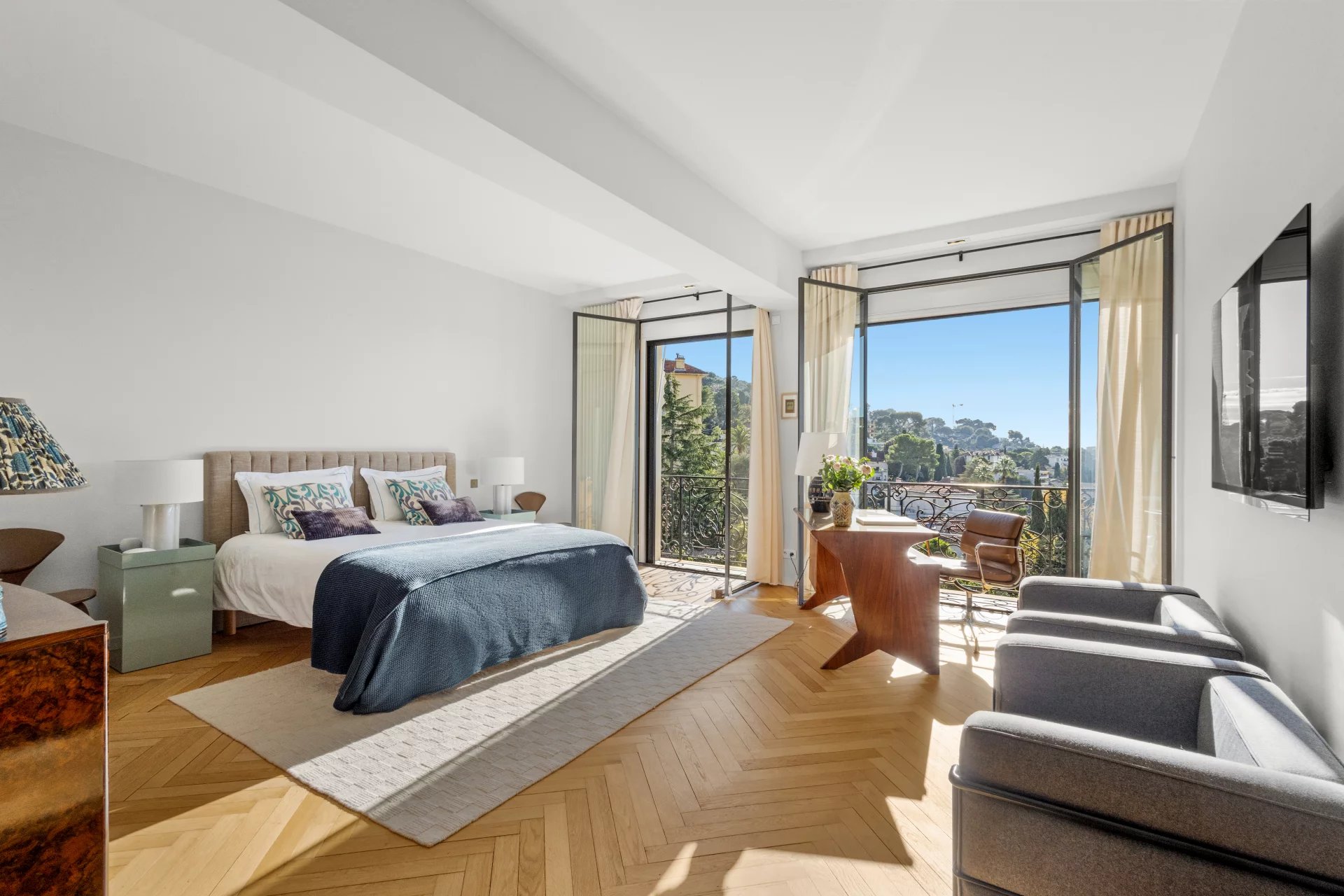 Spacious room with sea view, open windows, modern and bright furniture.