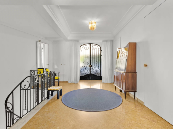 Interior of a private mansion in Le Cannet with a spacious entrance hall and a wrought iron door.