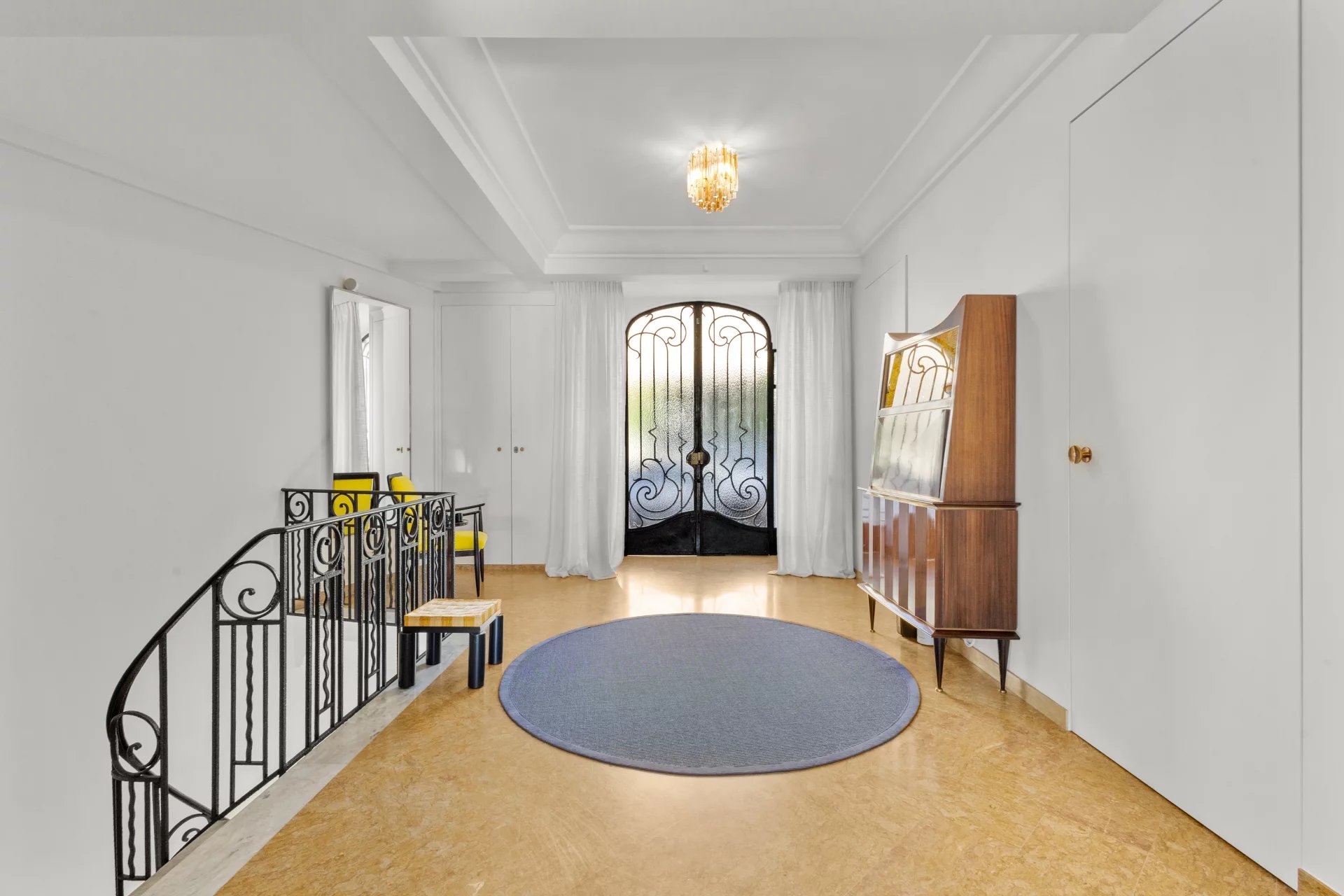 Interior of a private mansion in Le Cannet with a spacious entrance hall and a wrought iron door.