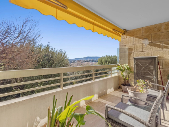 Terrace of a corner apartment in Le Cannet with unobstructed views, garden furniture and plants.