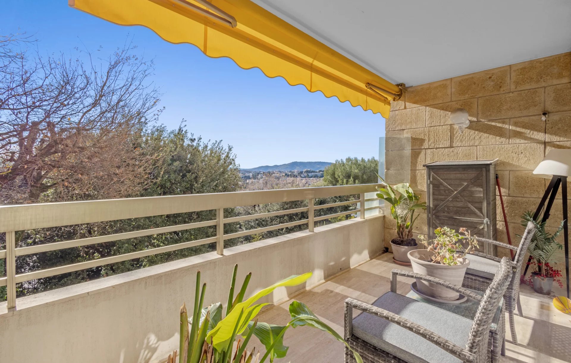Terrasse d'un appartement d'angle au Cannet avec vue dégagée, mobilier de jardin et plantes.