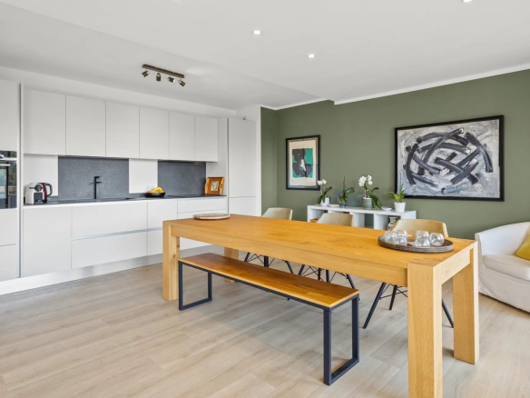 Intérieur d'un appartement moderne avec salle à manger et cuisine ouverte, décoré avec goût.