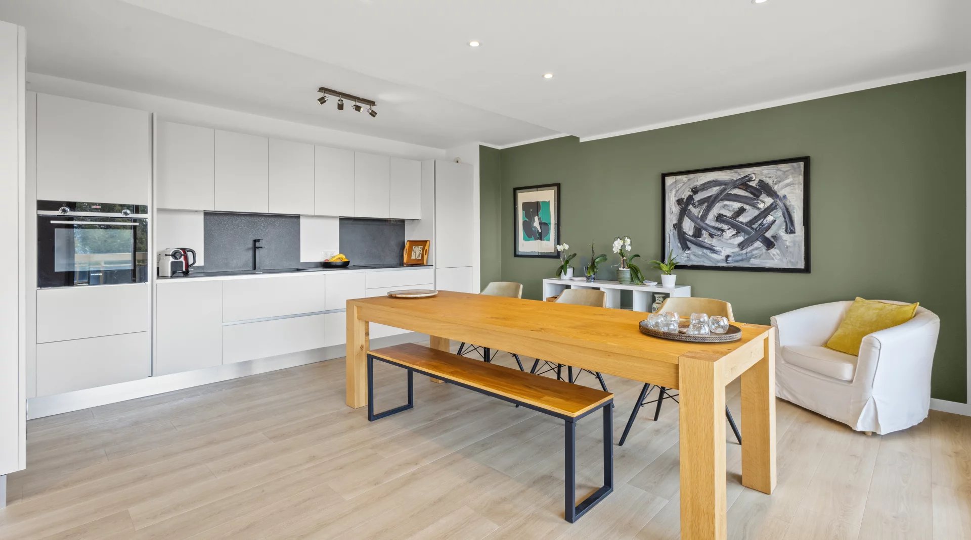 Intérieur d'un appartement moderne avec salle à manger et cuisine ouverte, décoré avec goût.