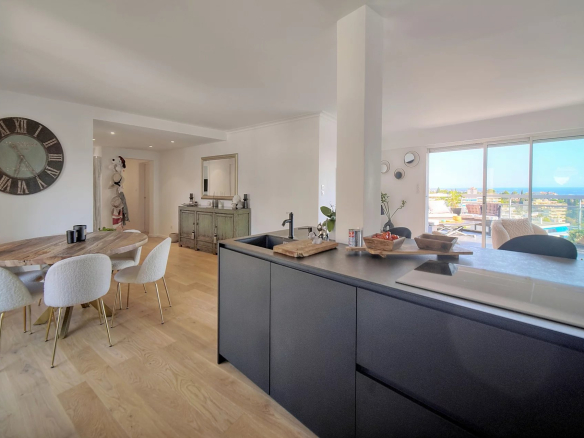 Interior of a modern apartment with open kitchen and sea view in Le Cannet.