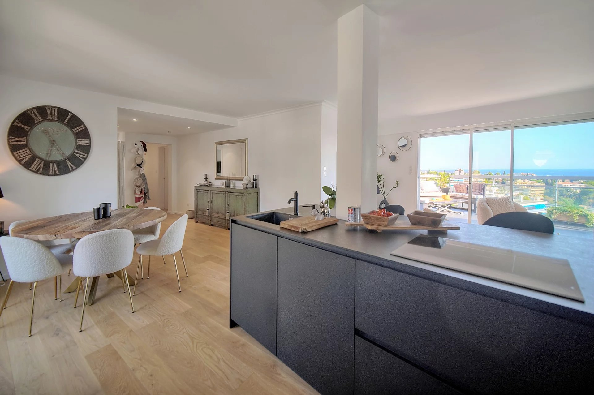 Interior of a modern apartment with open kitchen and sea view in Le Cannet.